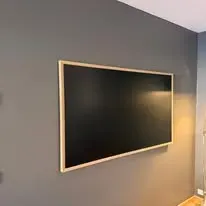 Framed blackboard, mounted and levelled.